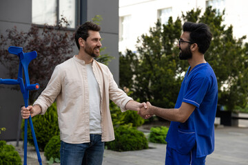 Man with crutches talking to a doctor and feeling excited