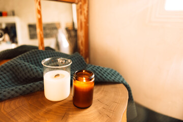 Two lighted candles in a ceramic and glass candlestick on a wooden table.