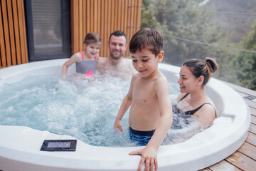 Happy family with two small children have fun in the jacuzzi