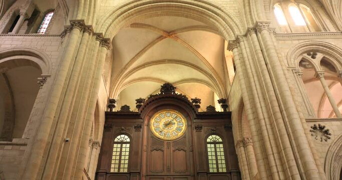 Low angle shot of a a large clock inside the Abbey of Saint-Étienne Abbaye aux Hommes, Caen, France. 4K.