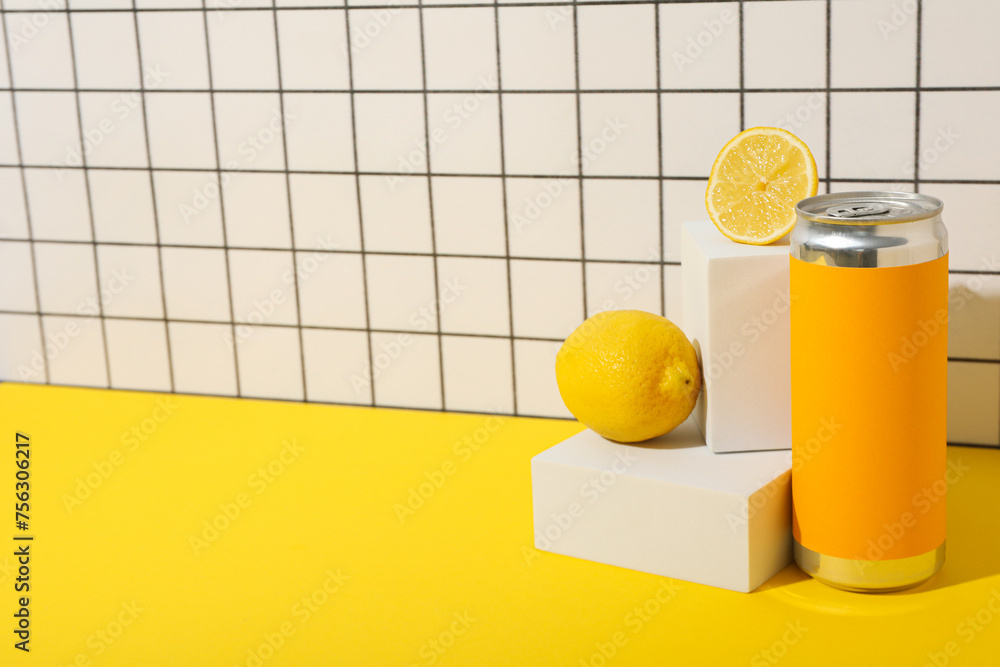 Sticker tin can and lemons on yellow table on light background, space for text