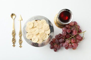 Bread on plate, cup, grapes and cutlery on white background, top view