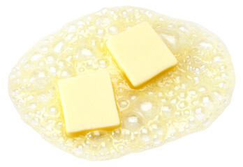 Two pieces of butter melting isolated