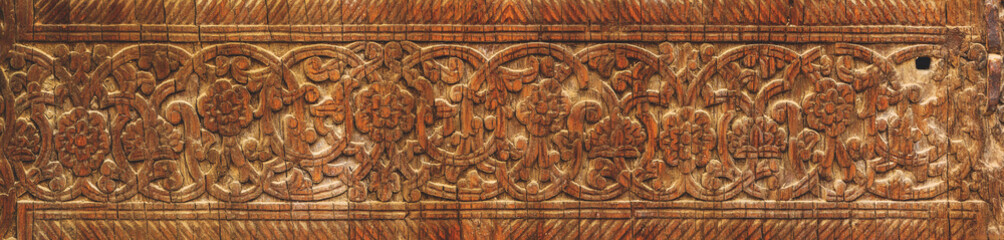 Elaborate wooden carving depicting traditional floral patterns in a warm, rich brown tone. Khiva (Xiva), Turkey (Turkiye)