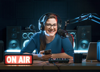 Happy radio host holding a smartphone