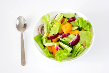 salad with tomatoes, cucumber and red onion in bowl close up
