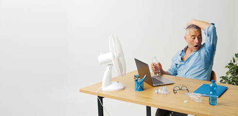 Businessman suffering from the heat in the office