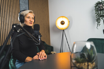 woman radio presenter talking in a live podcast , working in a studio. High quality photo