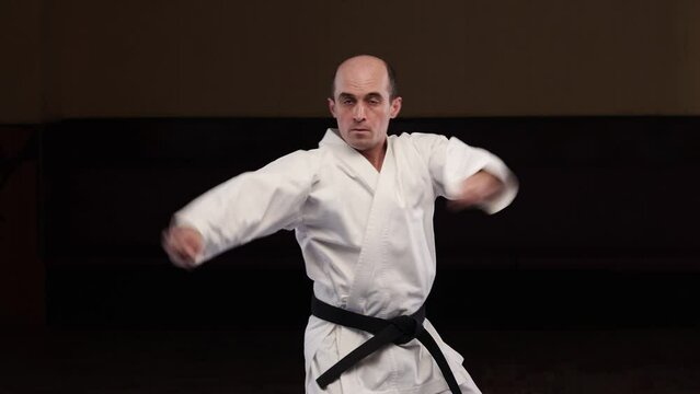 Experienced athlete with black belt training formal exercises