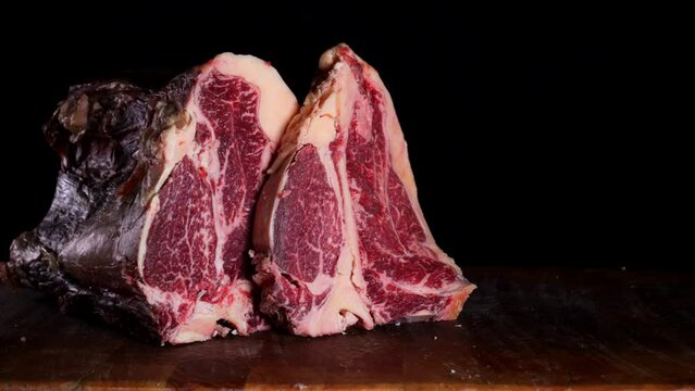 il macellaio taglia la bistecca con il coltello affilato.
in macelleria: Primo piano della carne rossa da cuocere alla griglia.