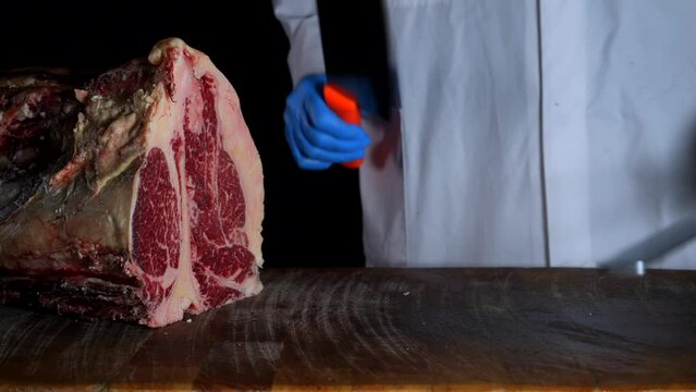il macellaio taglia la bistecca con il coltello affilato.
in macelleria: Primo piano della carne rossa da cuocere alla griglia.
