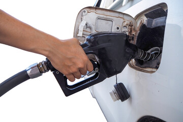 Hand pumps gasoline into car at station