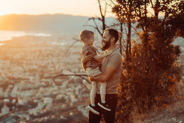 Father and son bond radiating joy and warmth as they share a moment of love in the soft haze of a blurred cityscape