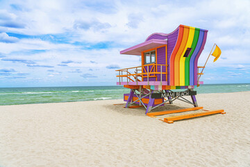  Vibrant, pastel view of lifeguard tower colorful painted as LGBT flag under bright blue sky on...