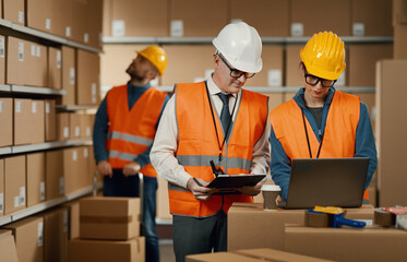 Warehouse workers checking orders on the laptop