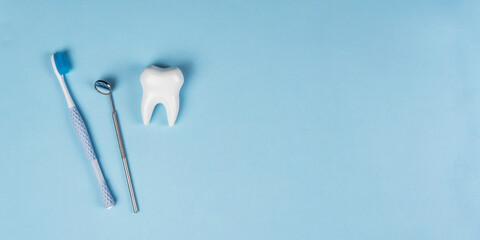 Healthy white tooth, toothpaste and toothbrush on a blue background. The concept of dentistry, health, health care, oral care. Oral hygiene, professional teeth cleaning. Banner for a dental clinic