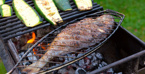Dorado fish is cooked on the grill, on coals in the garden. - 756332078