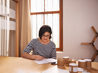 Businesswoman, sample and planning at desk, product and notes for startup business. Administration, research and inventory for female brand owner in office, paper and writing for quality control