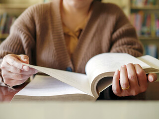 Learning, education Hand of Senior woman sitting   reading fiction book on wooden table,relax and...