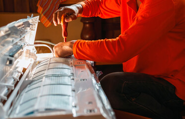 Hand of technician use a screwdriver to tighten the air conditioning assembly nuts, Air conditioning technicians Prepare to  install new air conditioner in homes.