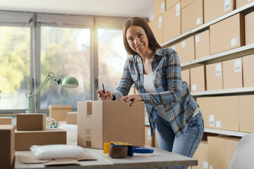 E-commerce owner writing an address on a delivery box