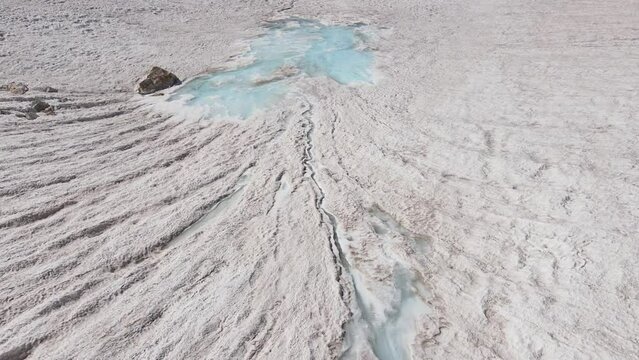 A pool of fluid among the snow, a geological phenomenon in the natural landscape