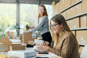 Shipping clerk wrapping products with plastic wrap