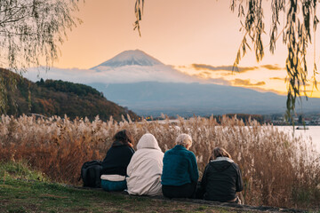 Family tourists enjoy with Fuji Mountain at Lake Kawaguchi , happy friends group travel and sightseeing Mount Fuji view. Landmark for tourists attraction. Japan Travel, Destination and Vacation - obrazy, fototapety, plakaty