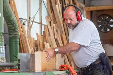 Tischler in seiner Werkstatt arbeitet an der Hobelmaschine - 756348289