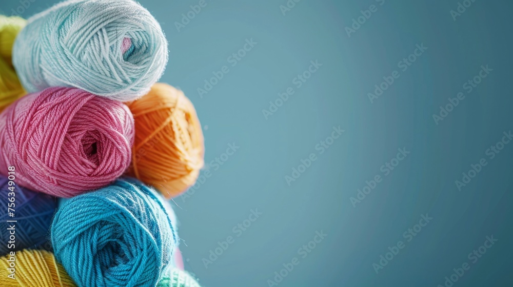 Poster assorted yarn balls in various colors neatly arranged against a blue backdrop, highlighting texture 