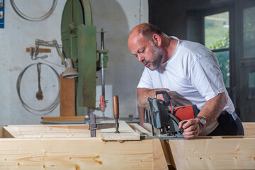 Tischler in seiner Werkstatt arbeitet mit Handkreissäge - 756349081