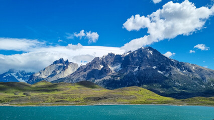View of Torres del Paine National park mountains, with beautiful blue sky and white clouds.