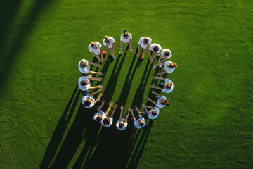 School Boys and Girls in Sports Team Standing in a Circle Together on Grass Pitch