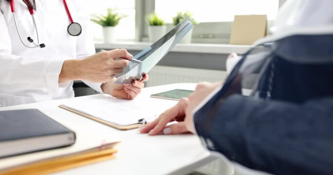 Traumatologist examines an X-ray of patient with broken arm. Earsh hand symptoms and treatment concept