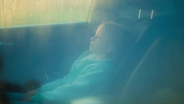 Child passenger sits car on stormy day