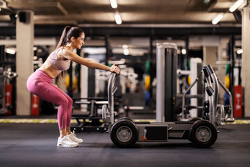 A strong sportswoman is pushing weights and doing exercises for gluts.