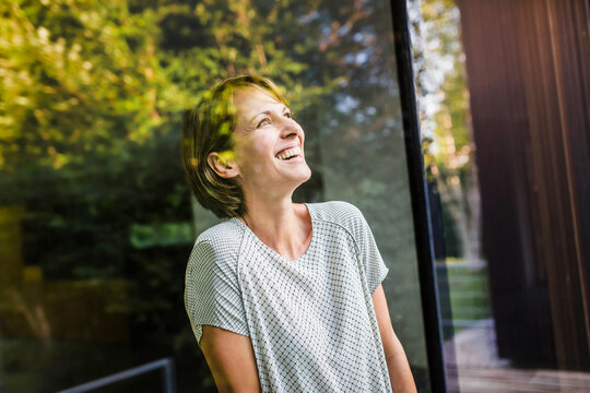 Frau am Fenster Blick nach draussen, Spiegelungen Laubbaum, Bayern, Deutschland