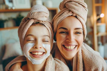 Fotobehang Mom and her daughter having fun together, making clay facial mask and wearing bathrobes. Mother with child doing beauty treatment together. Family time, spa and beauty, mothers day © Dina Photo Stories