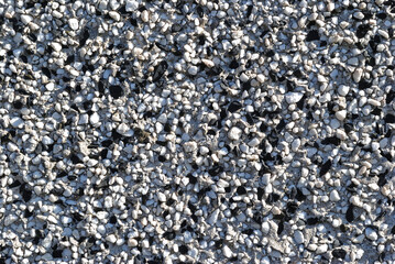 Close Up of Black and White Pebbles on Textured  Exterior Wall of Building