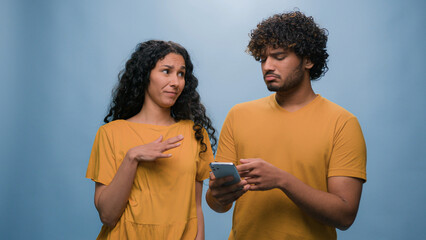 Multiracial couple Indian man Hispanic woman shopping online mobile phone store choosing goods in...