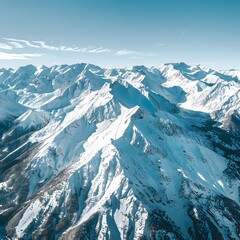 Aerial view of the snow-capped Alpine peaks under a clear blue sky, showcasing a serene winter panorama.