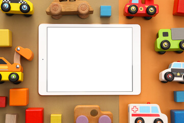 Modern tablet and toys on color background, flat lay. Space for text