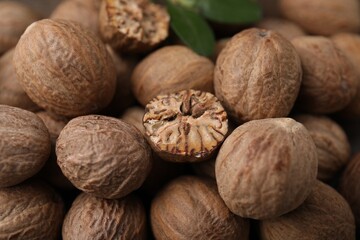 Whole and cut nutmegs as background, closeup