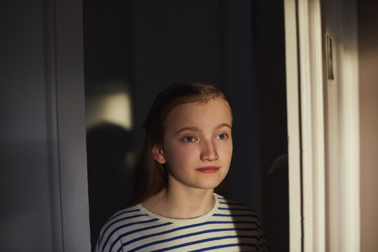 Portrait trauriges nachdenkliches Schulkind am Fenster, M&uuml;nchen, Bayern, Deutschland