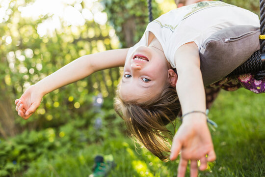 Kind turnt im Garten in der Wiese bei Gegenlicht, M&uuml;nchen, Bayern, Deutschland