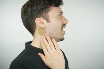 Man using Tinnitus treatment patch, Relief Patches of Symptoms of Tinnitus