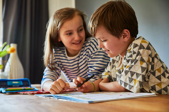 Kinder machen zu Hause gemeinsam Hausaufgaben, M&uuml;nchen, Bayern, Deutschland