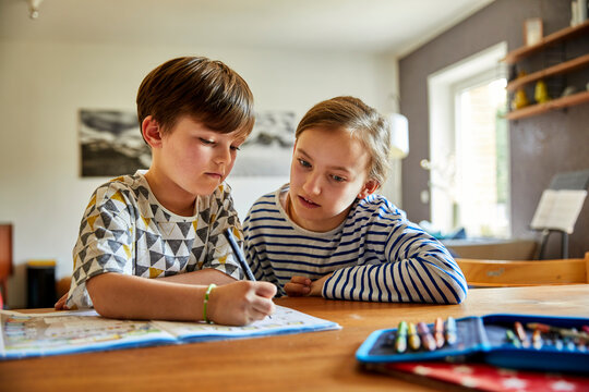 Kinder machen zu Hause gemeinsam Hausaufgaben, M&uuml;nchen, Bayern, Deutschland
