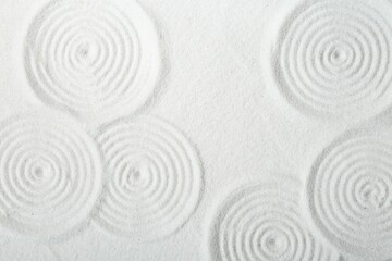 Fototapeta na wymiar Zen rock garden. Circle patterns on white sand, top view