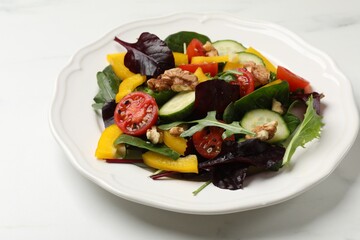 Tasty fresh vegetarian salad on white marble table, closeup